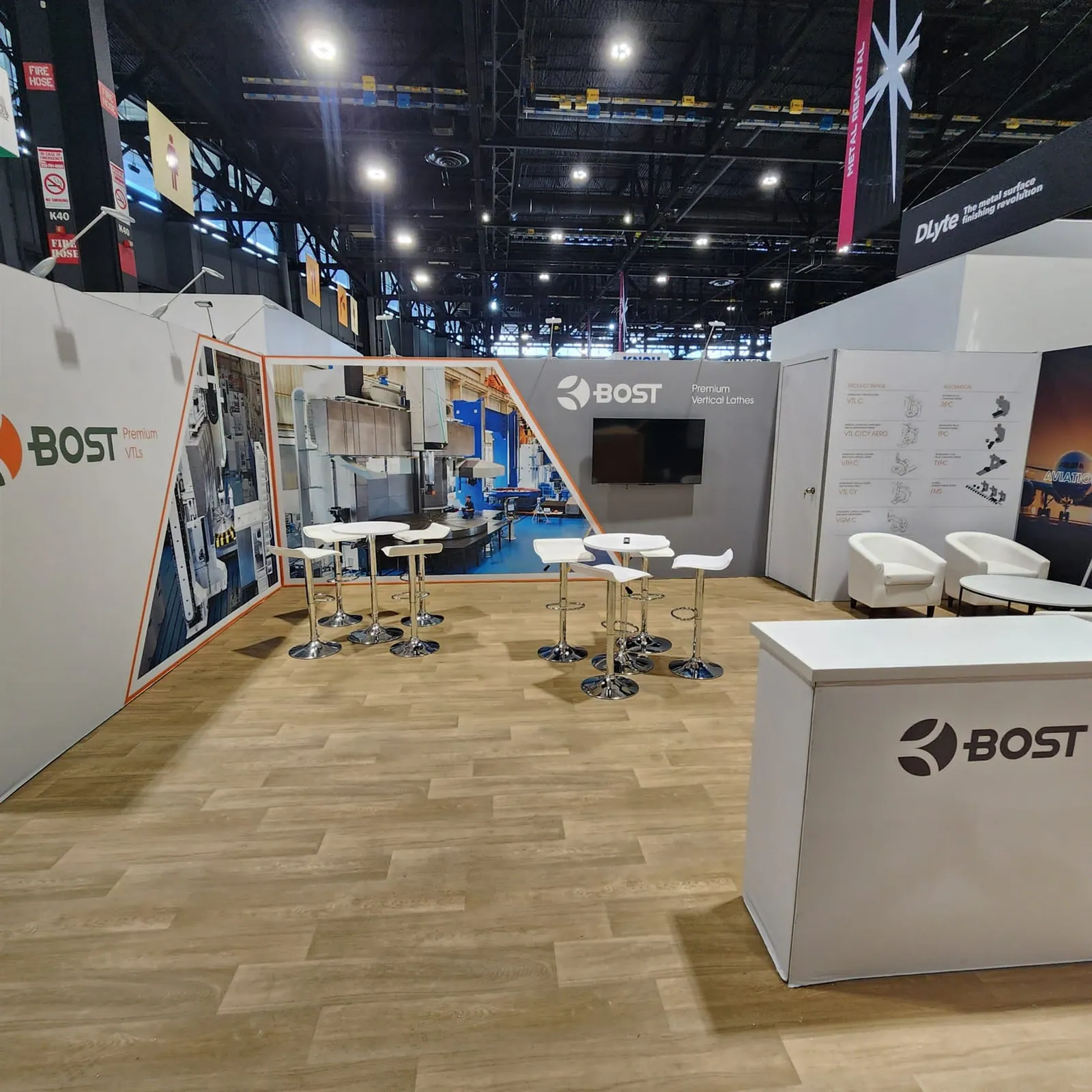 BOST exhibit with machine-tool photographs on the walls, a reception counter, white meeting furniture and timber-effect flooring.