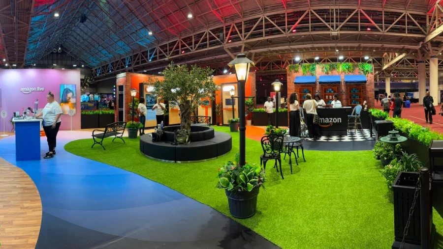 Amazon's indoor festival activation with a grassy courtyard, street lamps, planting, café seating and an Amazon-branded counter.