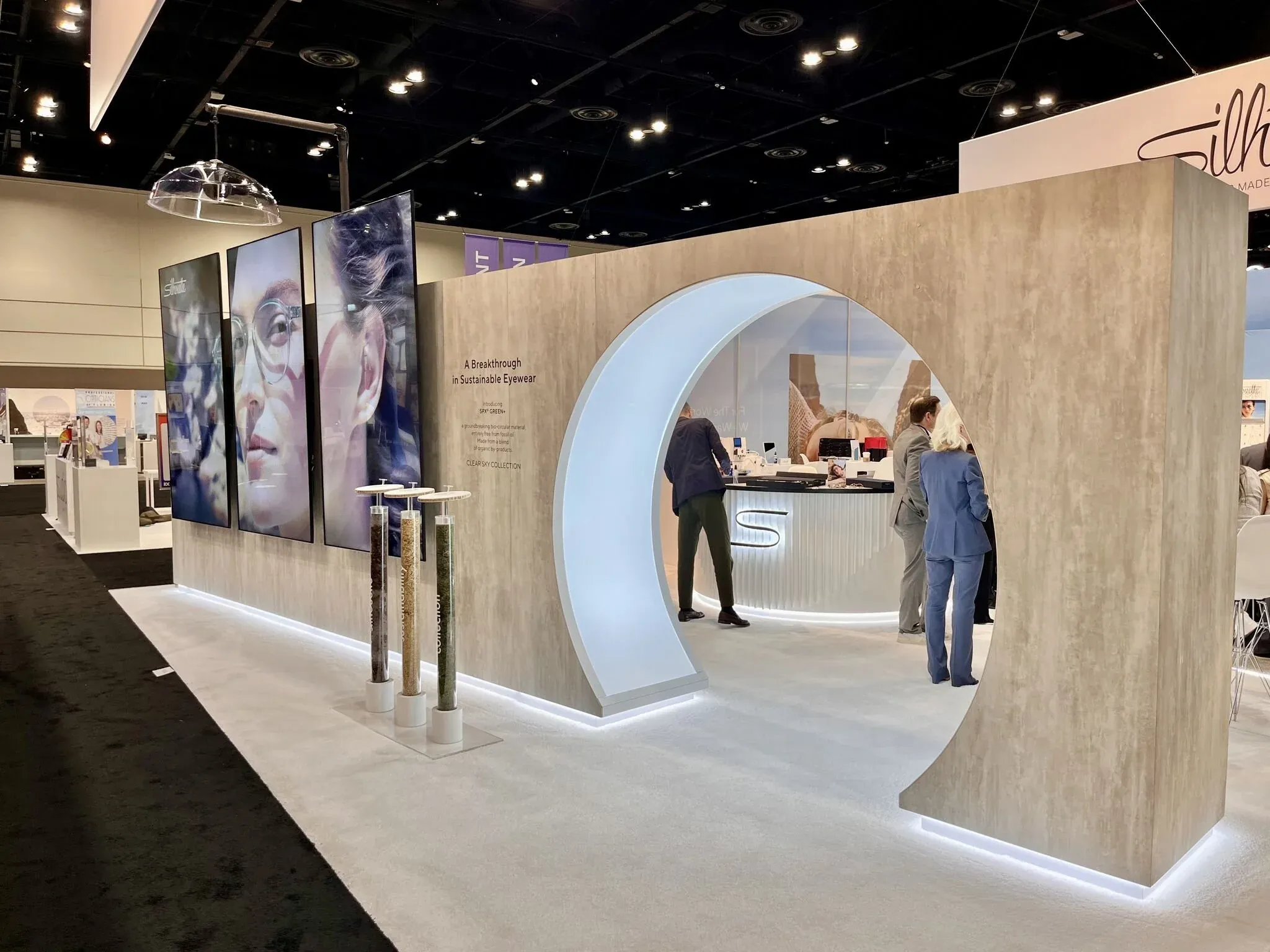 Silhouette eyewear exhibit at Vision Expo with illuminated arch and premium wood finishes