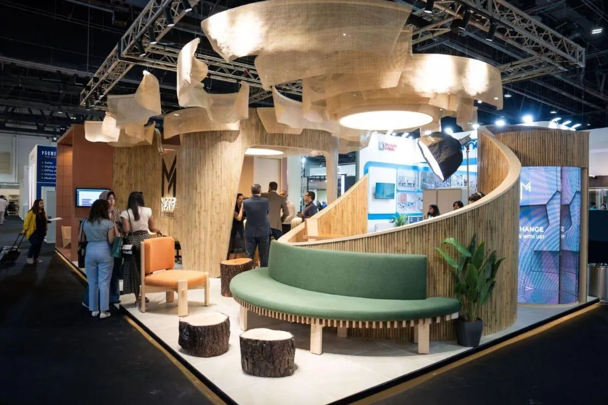 Sustainable custom trade show booth featuring natural wood materials, organic lighting, lounge seating and digital displays.