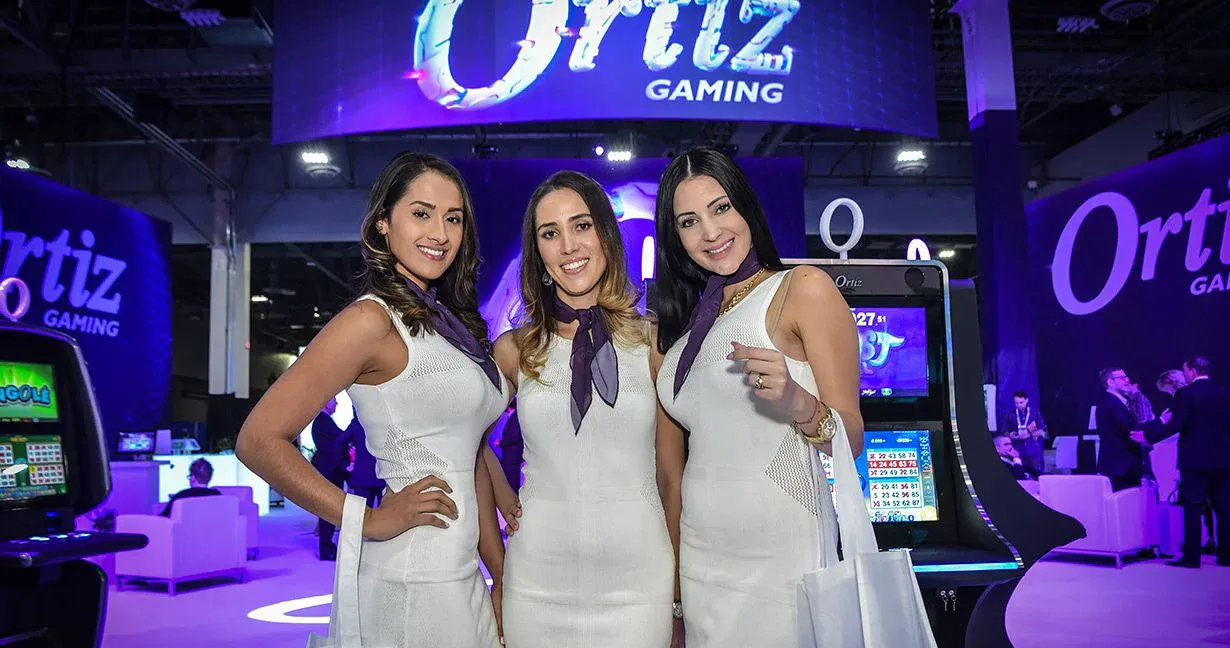 Large illuminated gaming exhibit with three professional female brand ambassadors at G2E Las Vegas
