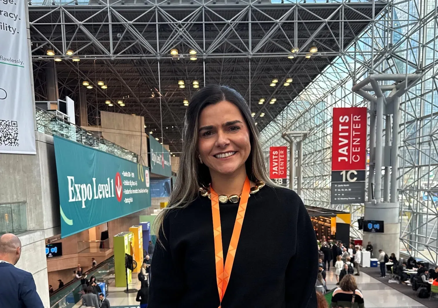 Attractive business exhibitor inside the Javits Center in New York with venue signs visible