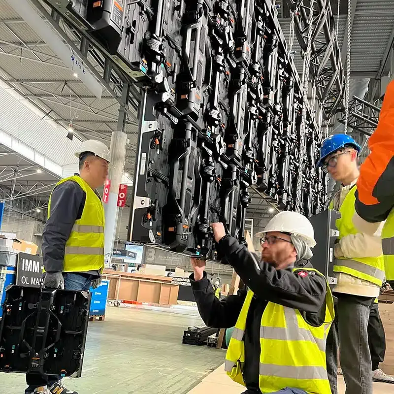 Trade show AV technicians connecting modular LED video wall panels before an event