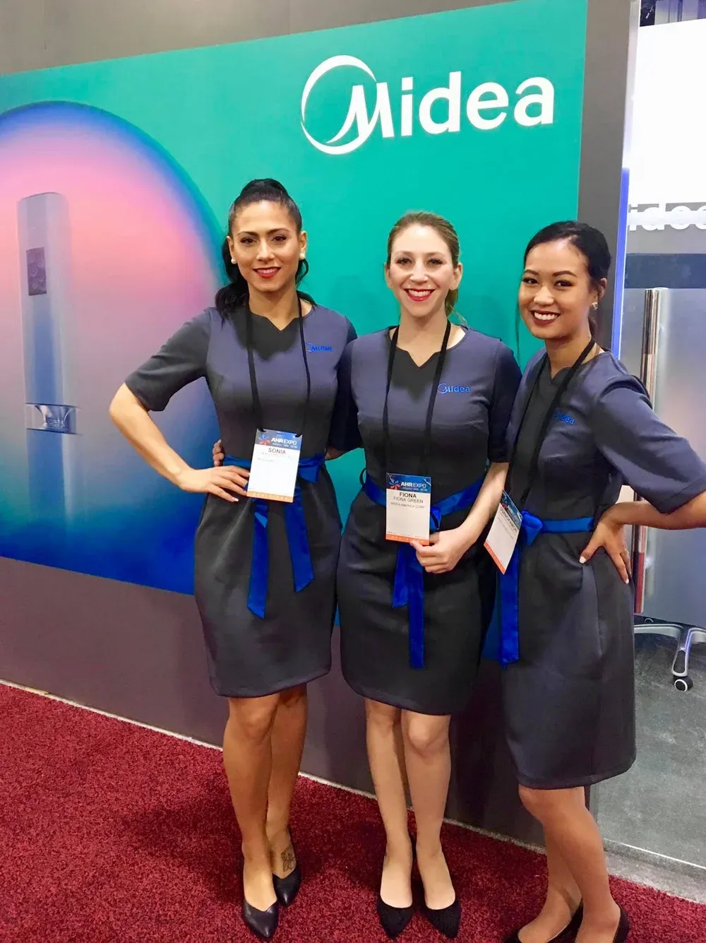 Attractive professional female brand ambassadors wearing coordinated business uniforms at a U.S. trade show