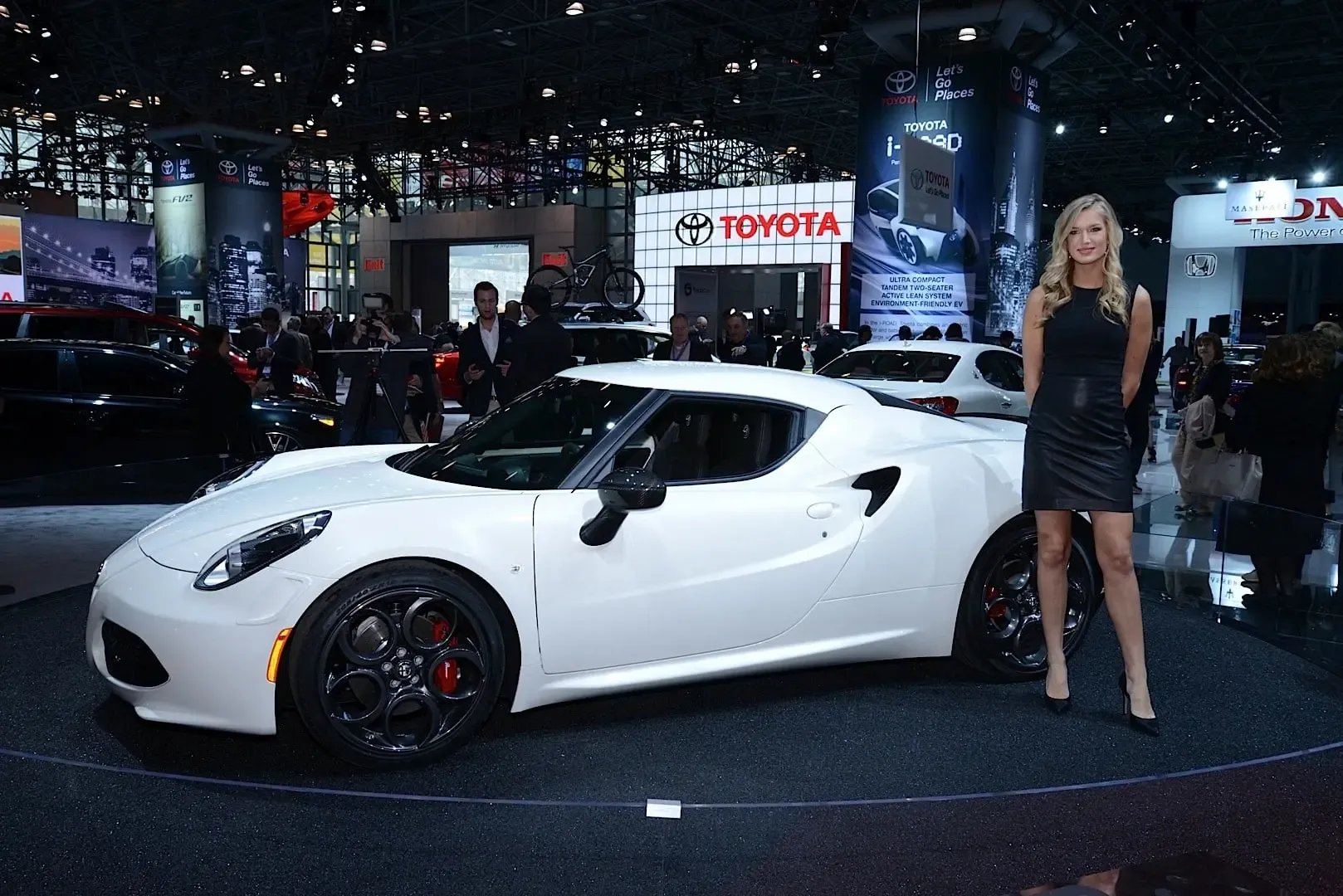 Attractive promotional model beside a sports car inside the Javits Center during the New York Auto Show
