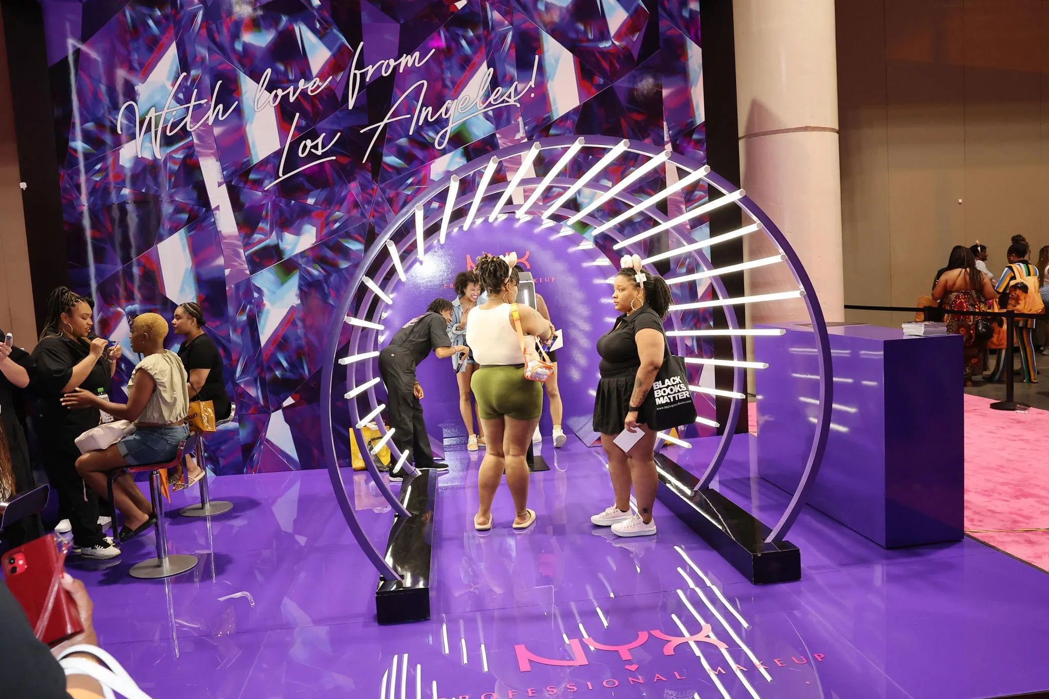 NYX Professional Makeup interactive exhibit booth with illuminated tunnel and live beauty demonstrations in New Orleans.