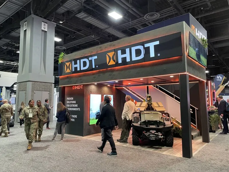 Large two-story HDT Global exhibit booth with bold branding and product demonstrations at AUSA in Washington, D.C.