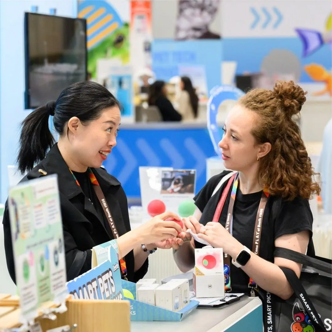 Pet product demonstration and sampling station with booth staff engaging visitors at Global Pet Expo.