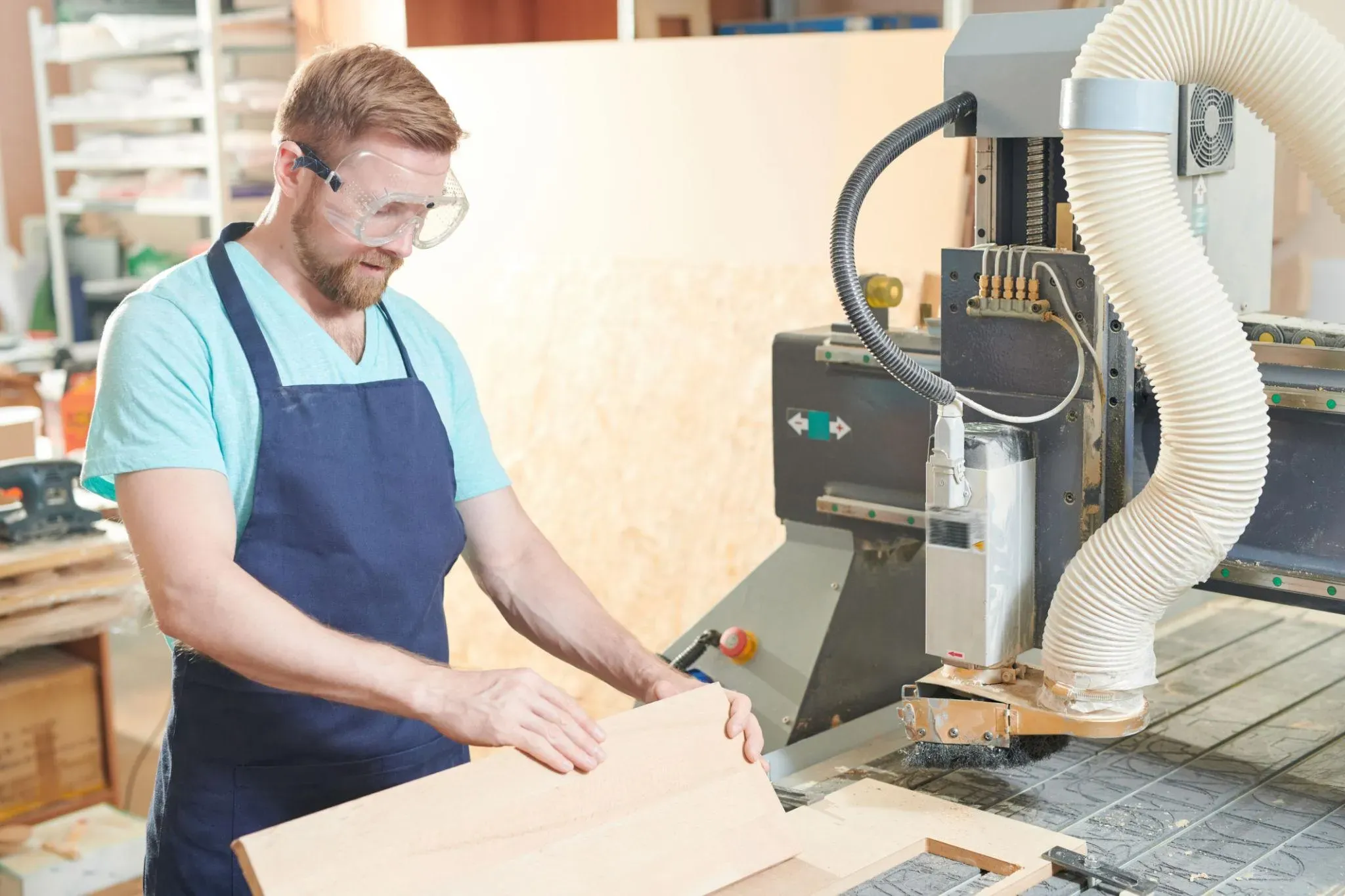 Craftsperson operating a CNC machine in an exhibit fabrication workshop
