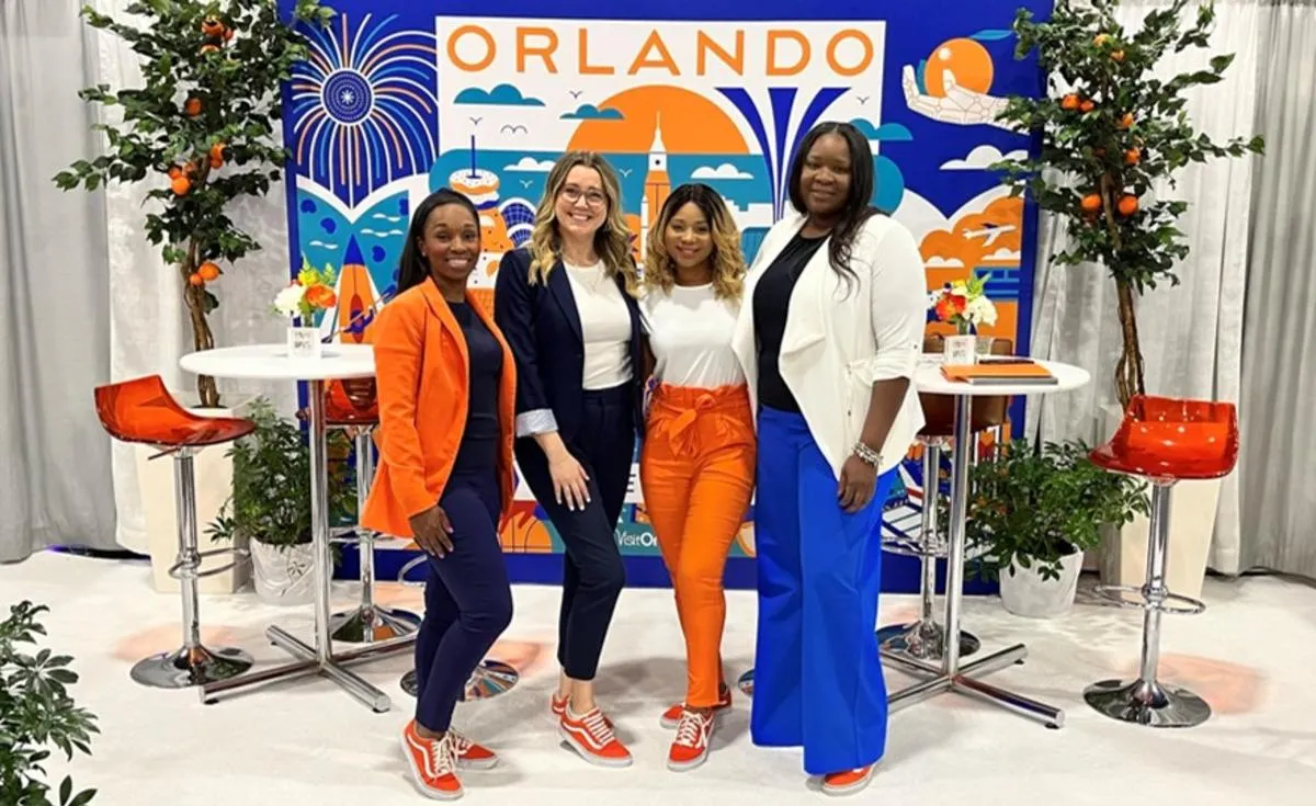 Visit Orlando promotional exhibit with professionally dressed female representatives and prominent Orlando branding