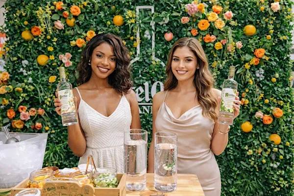 Two brand ambassadors presenting beverage products at a colorful trade show activation