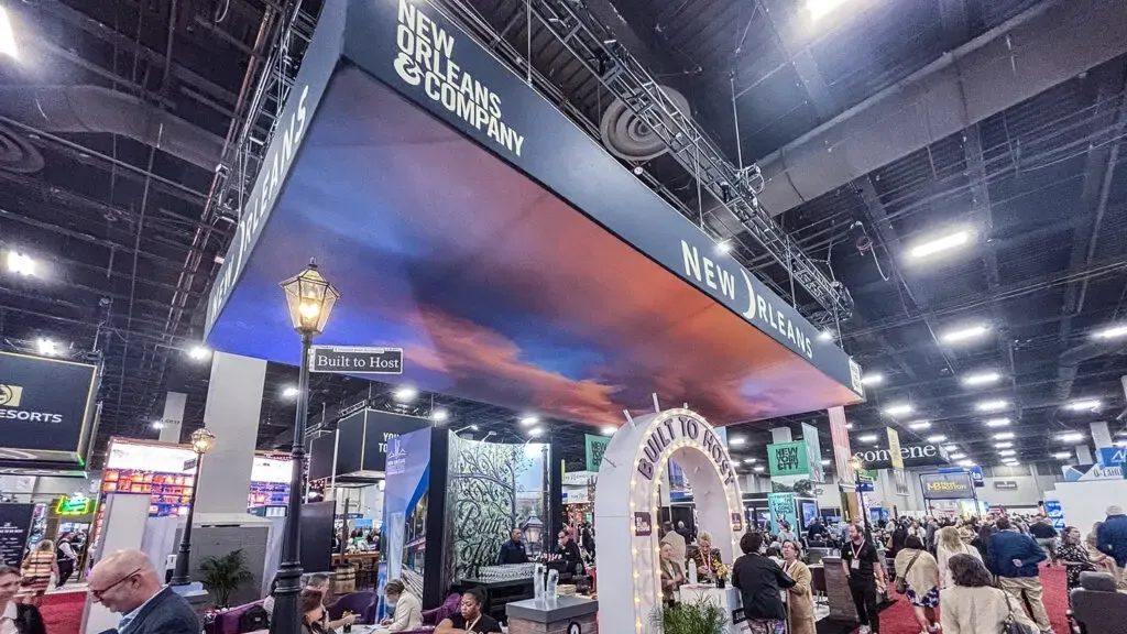 New Orleans themed custom trade show booth with large overhead signage and attendees