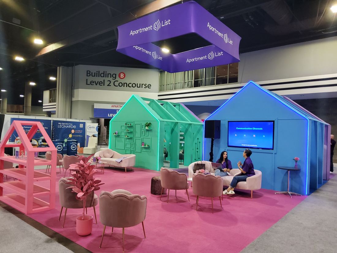Apartment List 20x40 island trade show exhibit with miniature house facades as demo stations