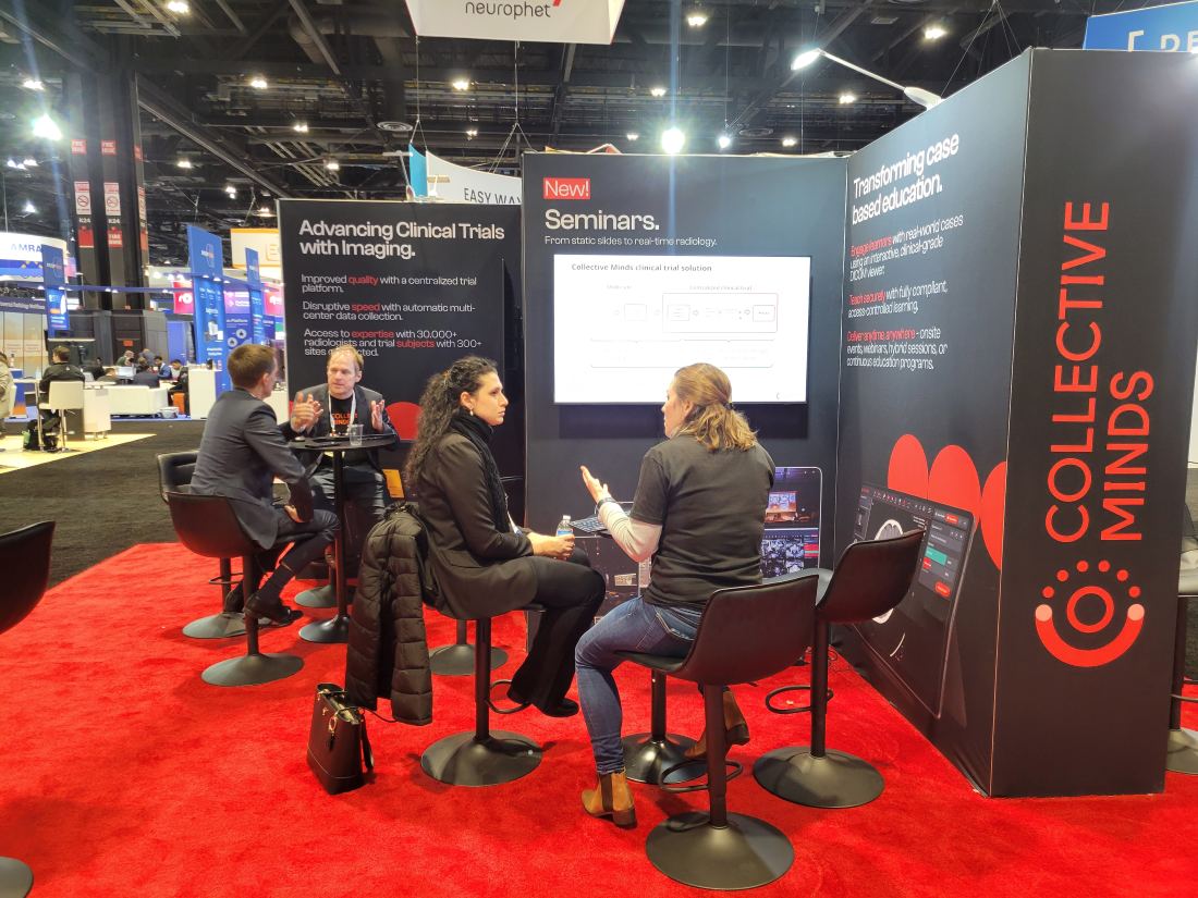 Collective Minds 20x20 island trade show booth with illuminated panel walls, branded pillar and meeting tables