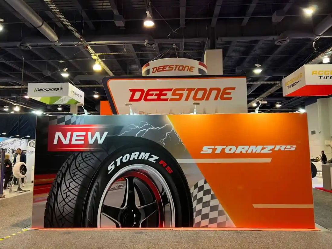 Deestone 20x20 island trade show exhibit with a tire brand tower structure
