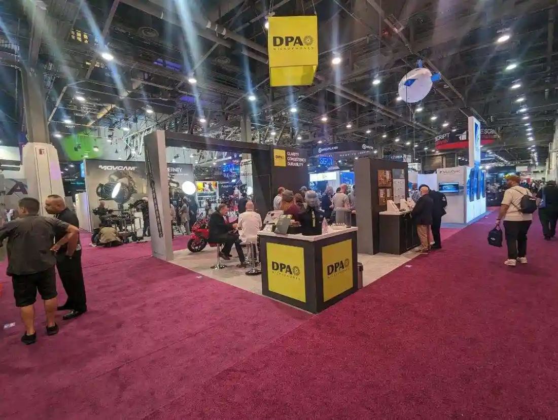 DPA Microphones 20x20 island trade show booth with red carpet entry and broadcast audio gear on display