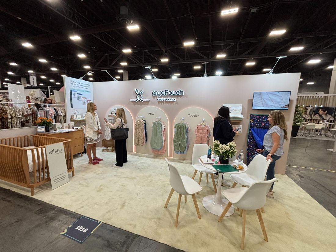 ergoPouch 10x20 inline trade show booth with an arched nursery-themed entry in soft pink