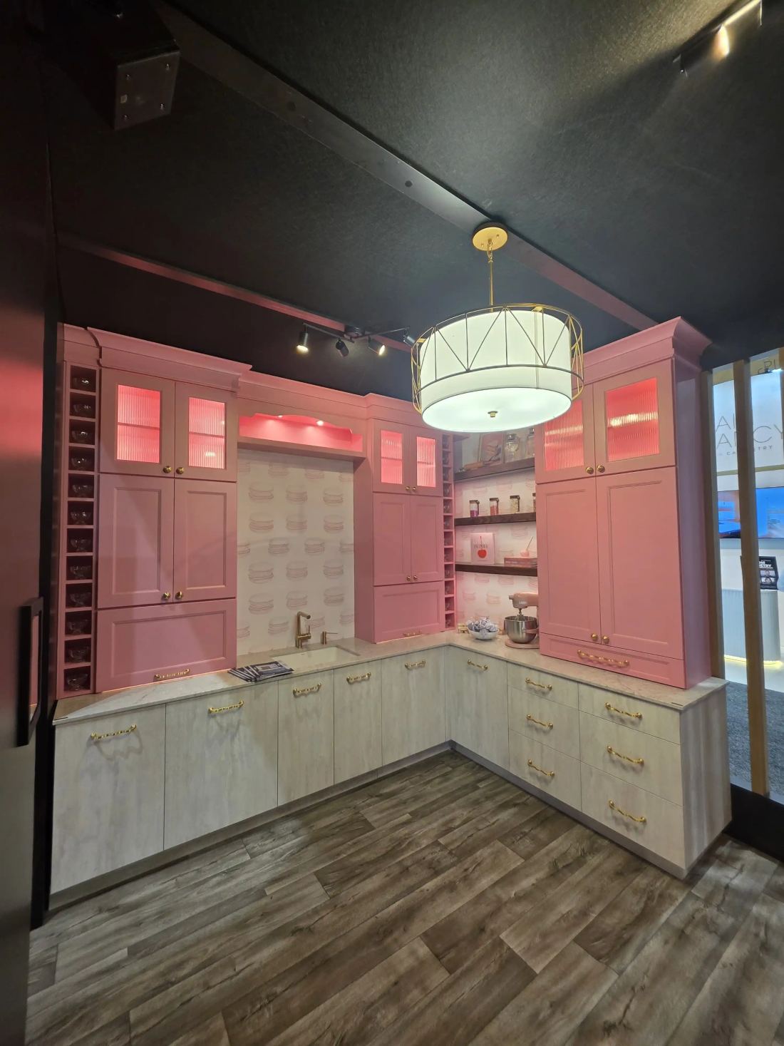 Fabuwood 40x40 island trade show exhibit with a vivid pink kitchen vignette and pendant lighting