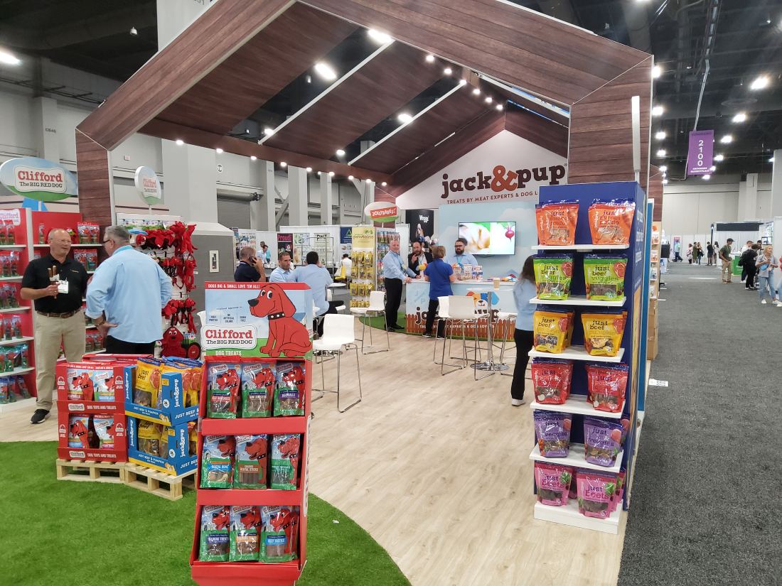 Jack and Pup 20x30 island trade show booth with staff greeting visitors at a branded counter