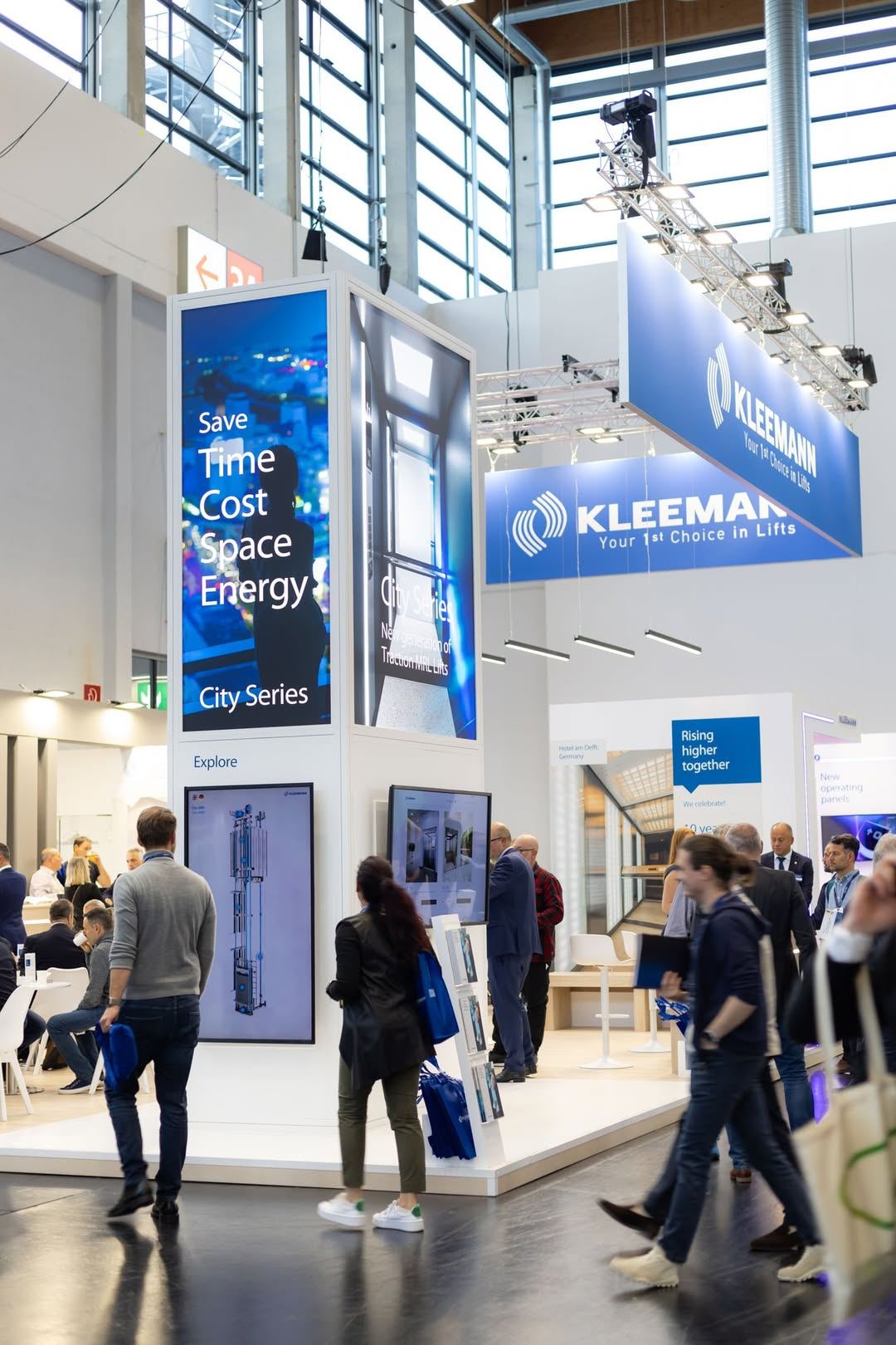 Kleemann 40x40 island trade show exhibit at Interlift with hanging signage, tower kiosks and lounge seating