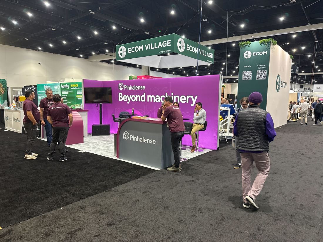 Pinhalense 10x20 inline trade show booth with magenta graphics and coffee machinery on display