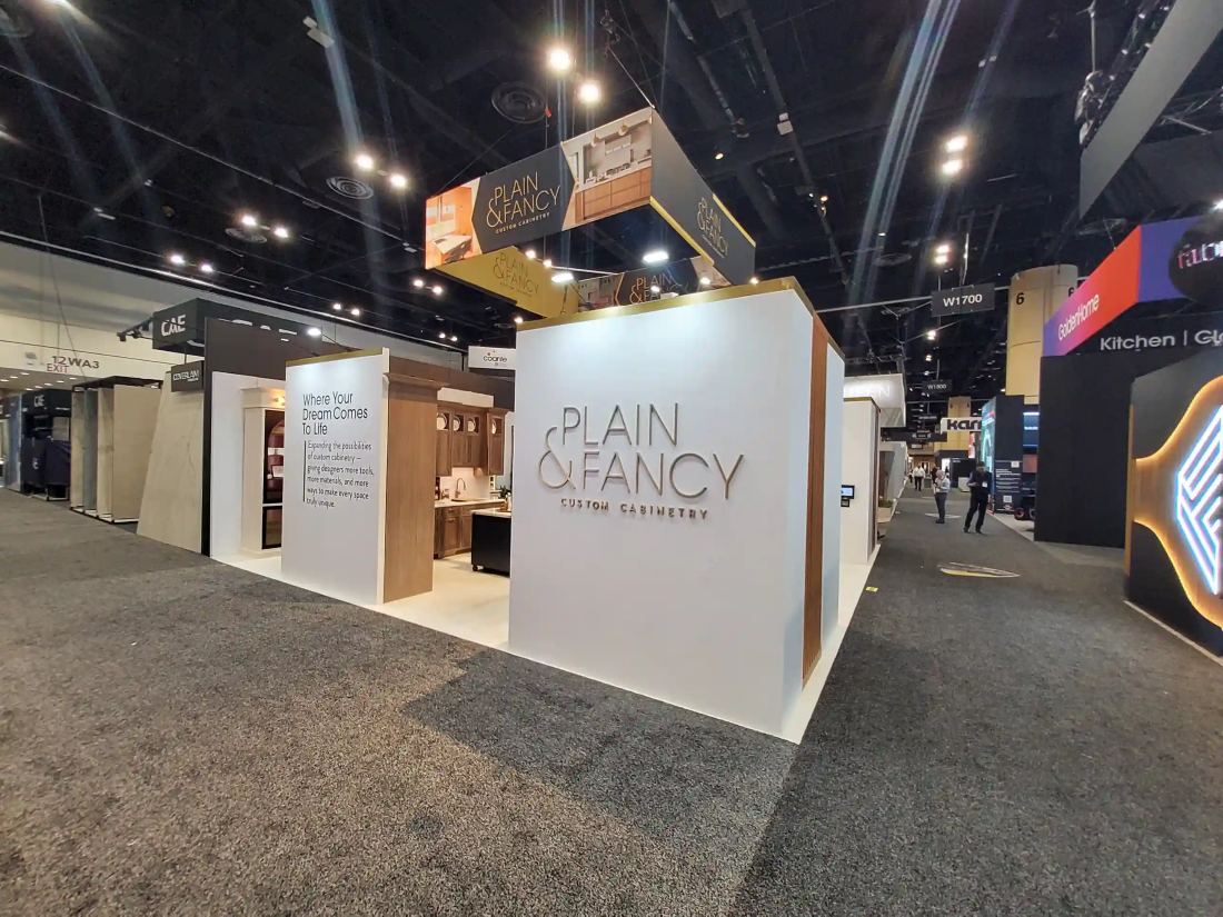 Plain and Fancy Custom Cabinetry 20x20 peninsula trade show booth with a white corner structure