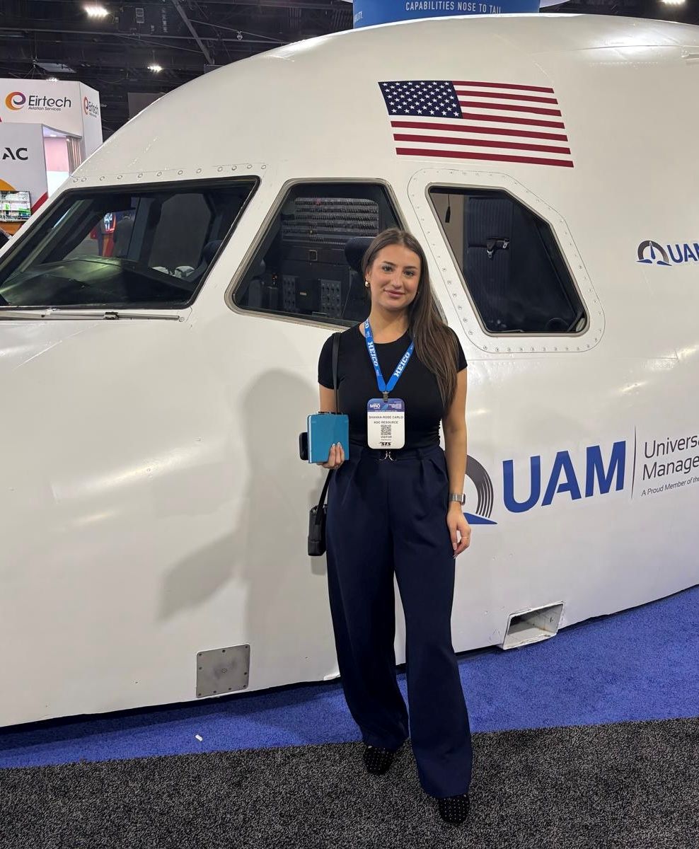 An attendee wearing an MRO Americas visitor badge stands in front of a full-scale aircraft forward fuselage display on the exhibition floor.