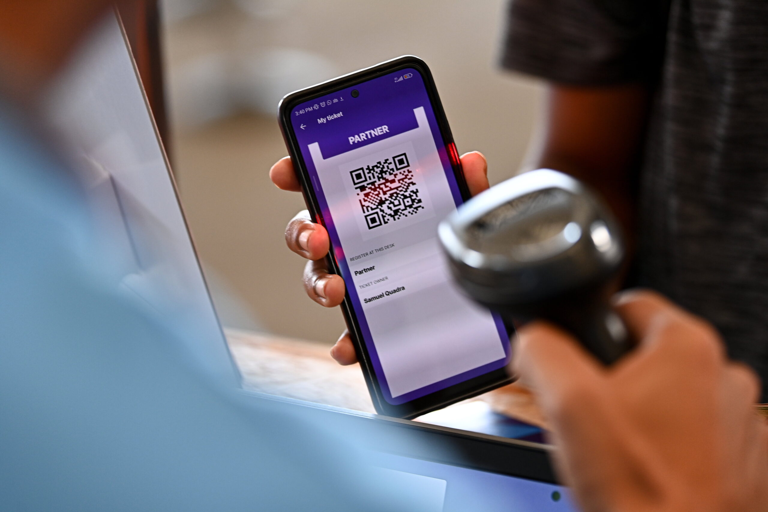A handheld scanner reading the QR code on an attendee’s phone at Web Summit Rio