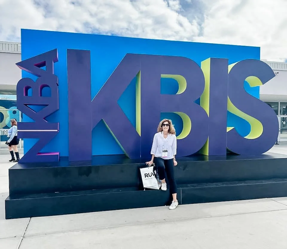 Attendee posing in front of the large NKBA KBIS sign outside the Las Vegas Convention Center