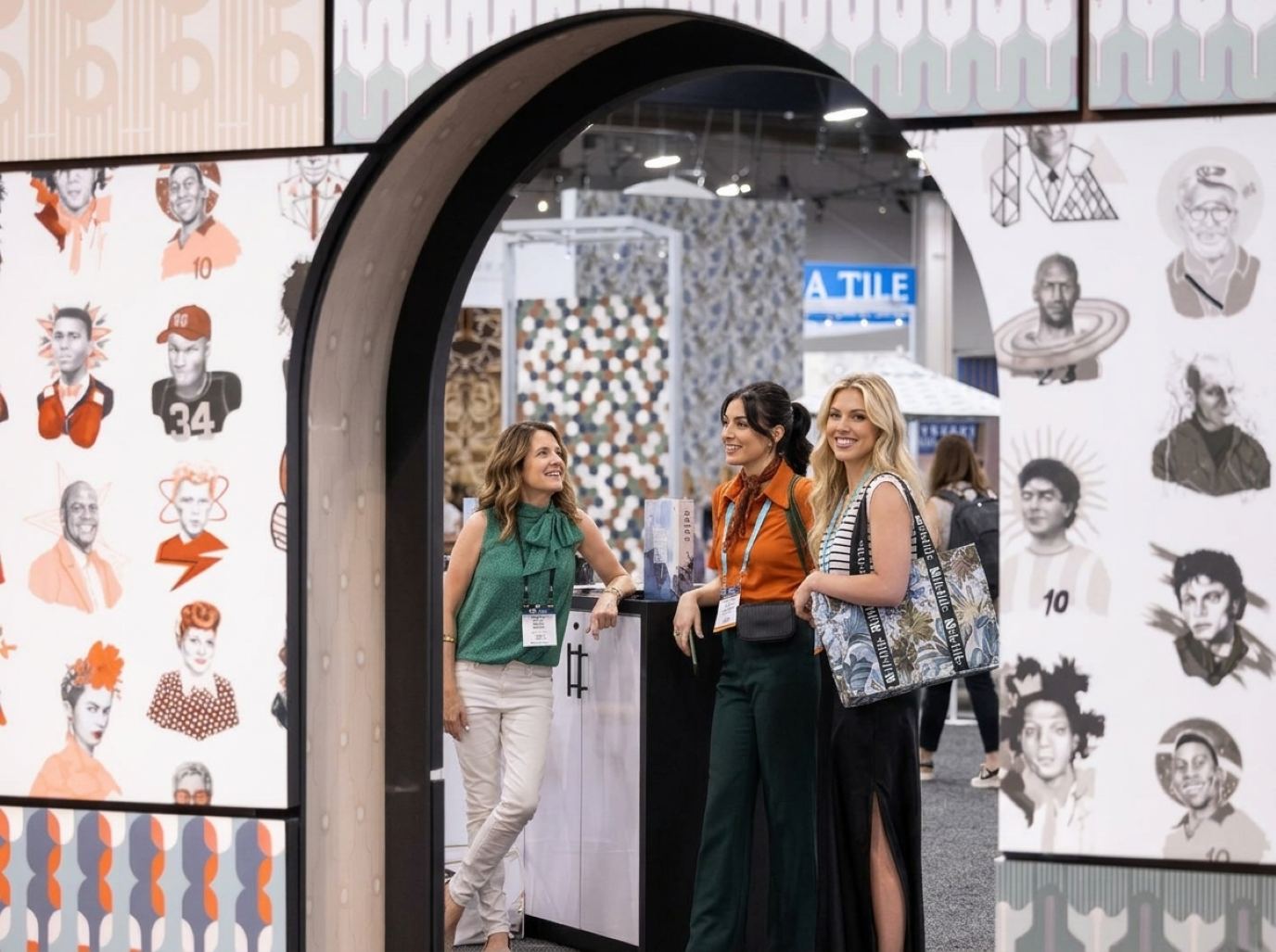 Booth reps in smart-casual colors with lanyard badges waiting at a counter inside an arched booth entrance, the welcome ProMat trade show models can give buyers